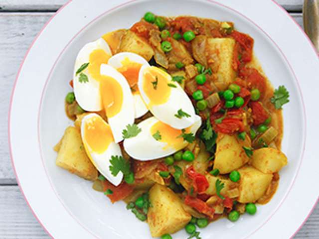 Foto Curry van aardappel met doperwtjes en parten ei