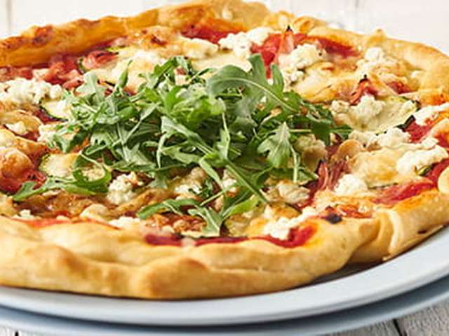 Foto Pizza met tomaat, courgette en rucola